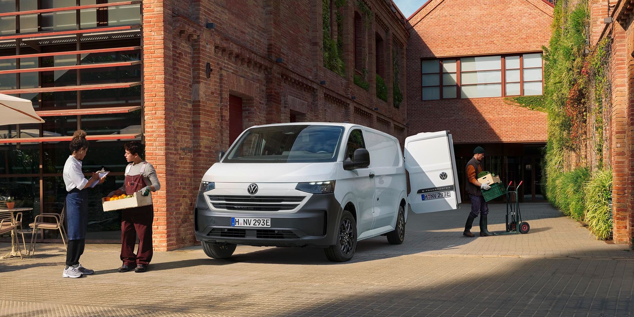 Volkswagen Transporter bílé barvy stojící u budovy