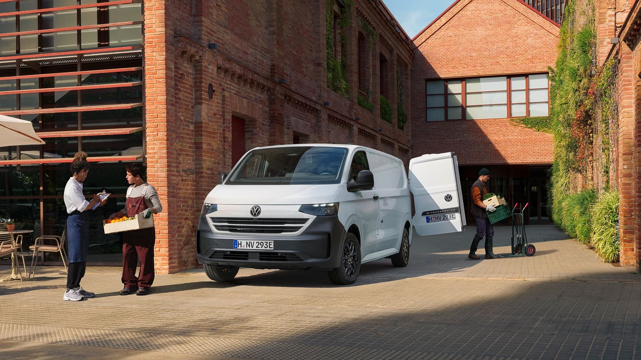 Volkswagen Transporter bílé barvy stojící u budovy