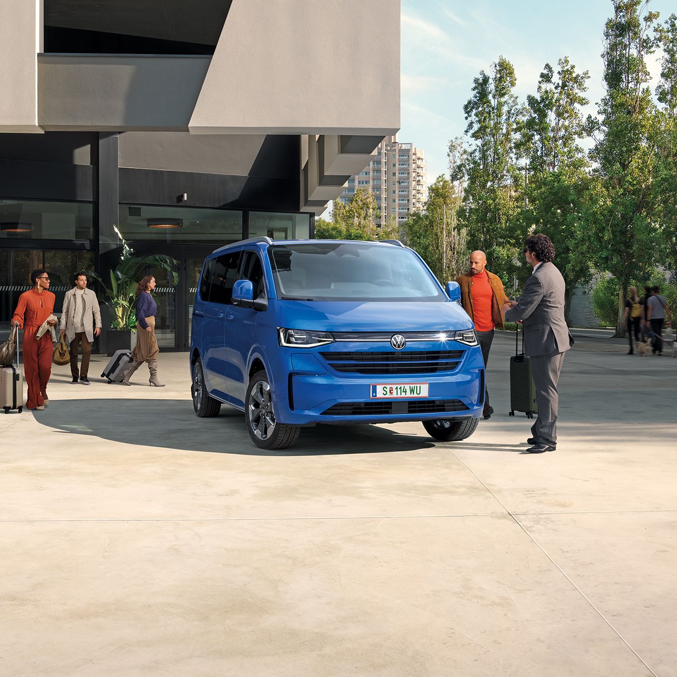 Volkswagen Caravelle v modré barvě před budovou