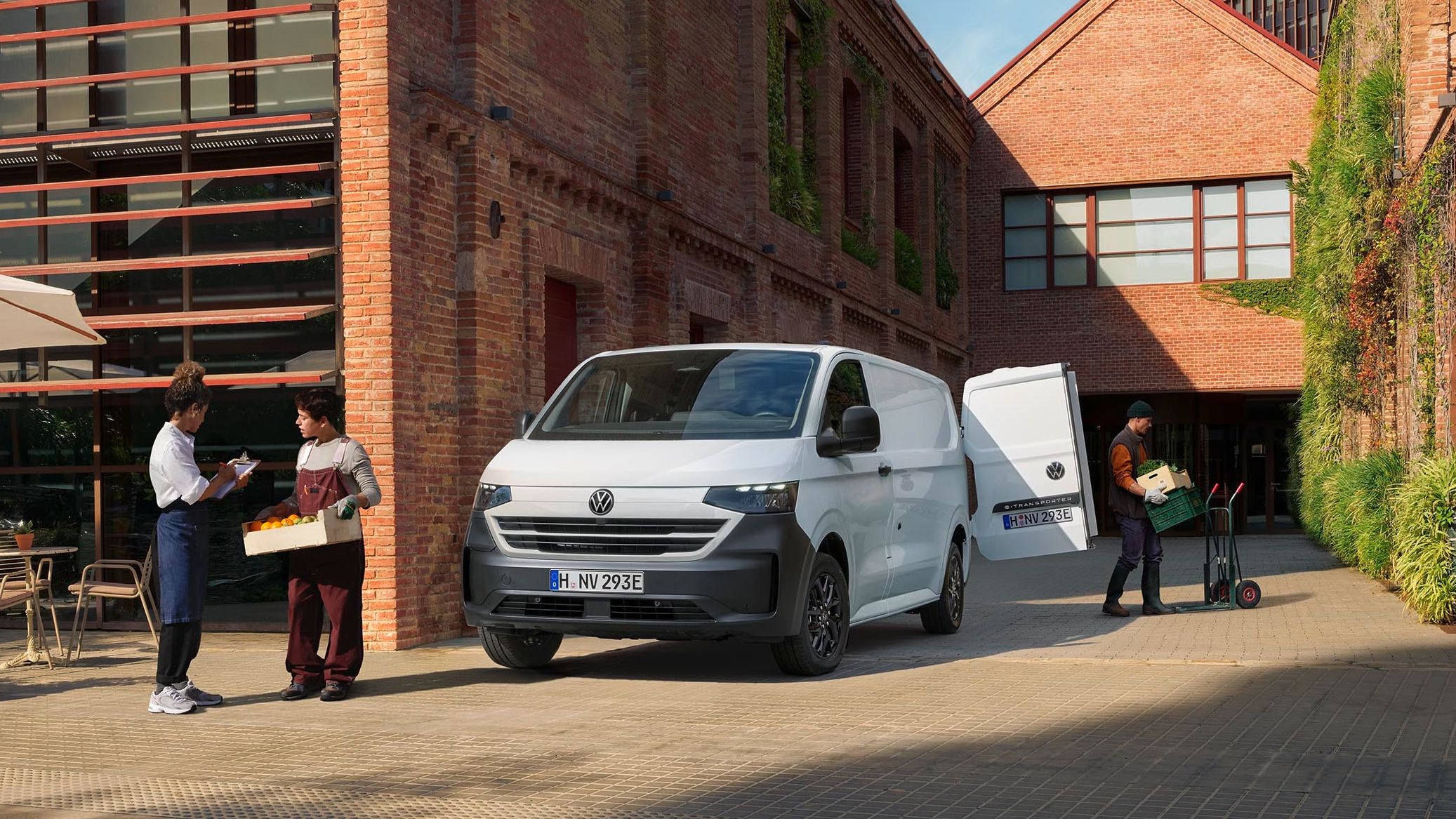 Volkswagen Transporter bílé barvy stojící u budovy