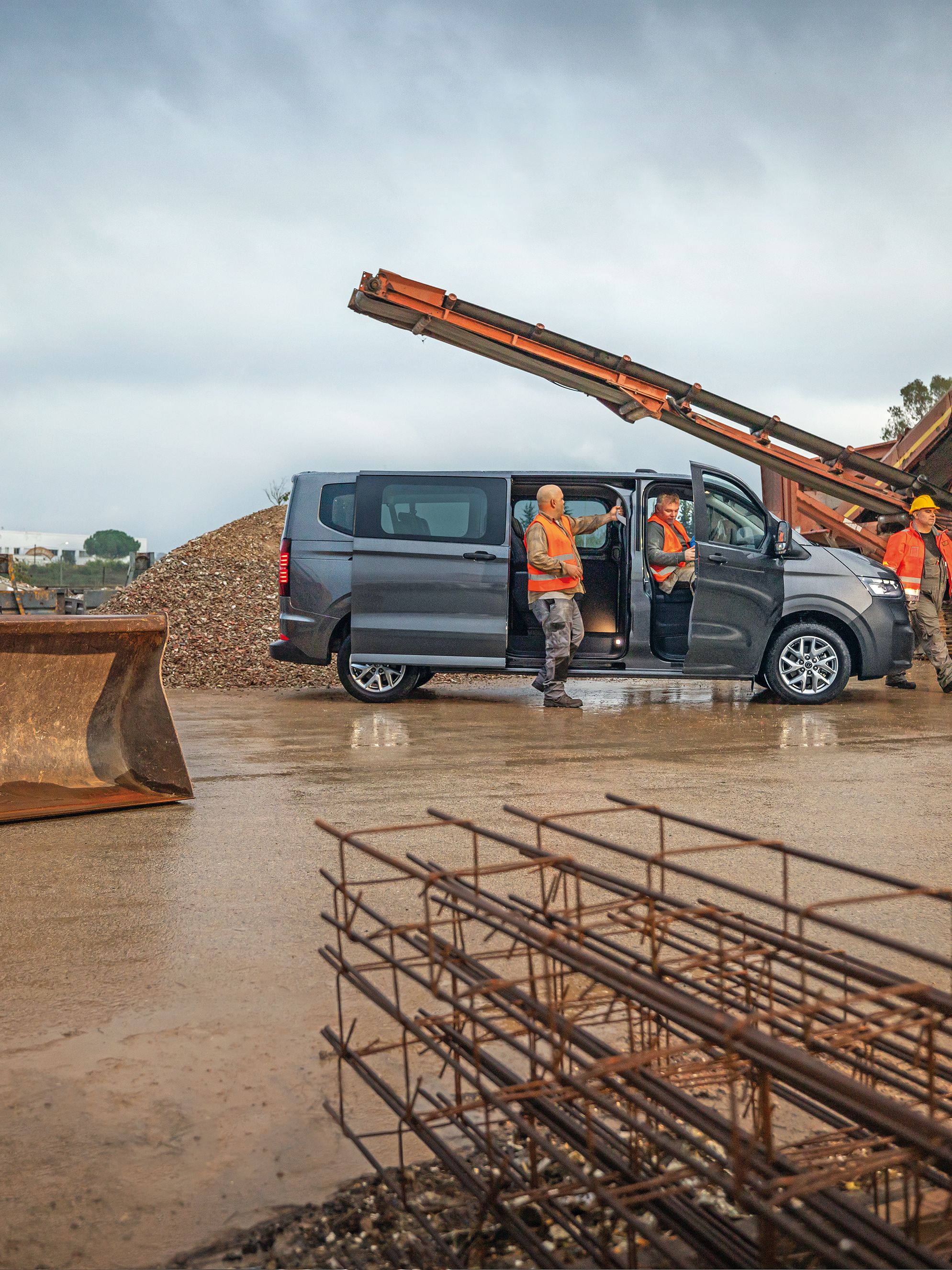 Volkswagen Transporter kombi v šedé barvě s lidmi
