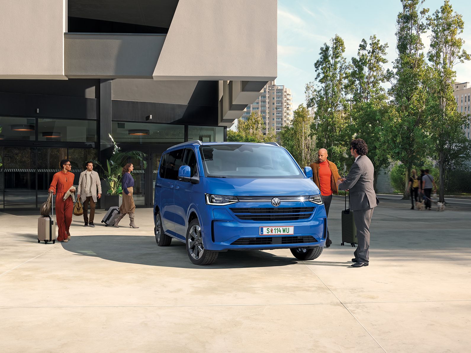 Volkswagen Caravelle v modré barvě před budovou