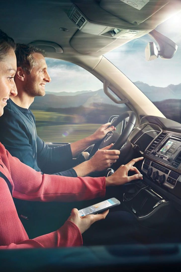 Ein Pärchen sitzt in einem VW und verwendet Car-Net