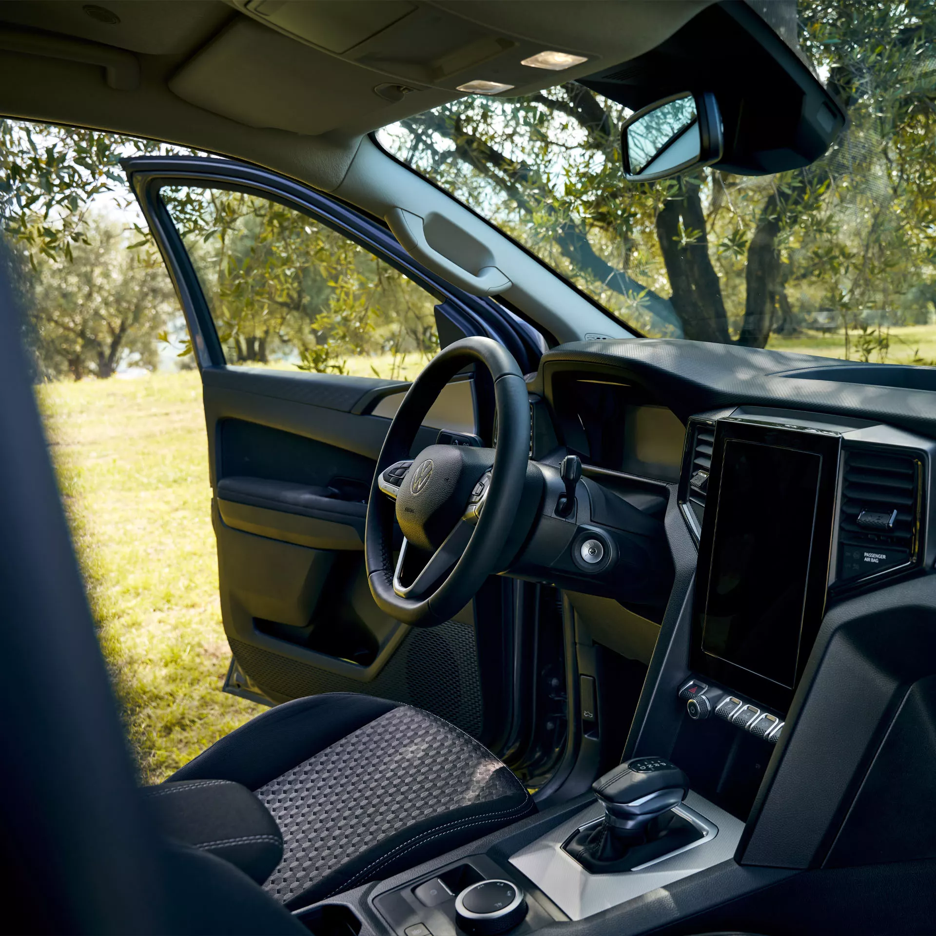 Volkswagen Amarok zevnitř s otevřenými dveřmi řidiče na straně řidiče 