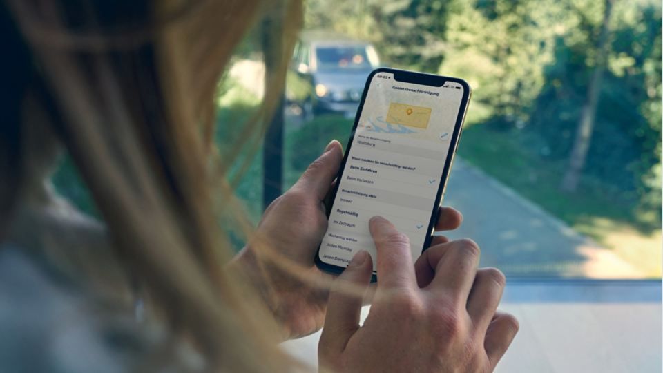 Zu sehen ist eine Frau die die VW We Connect App auf einem Smartphone bedient 