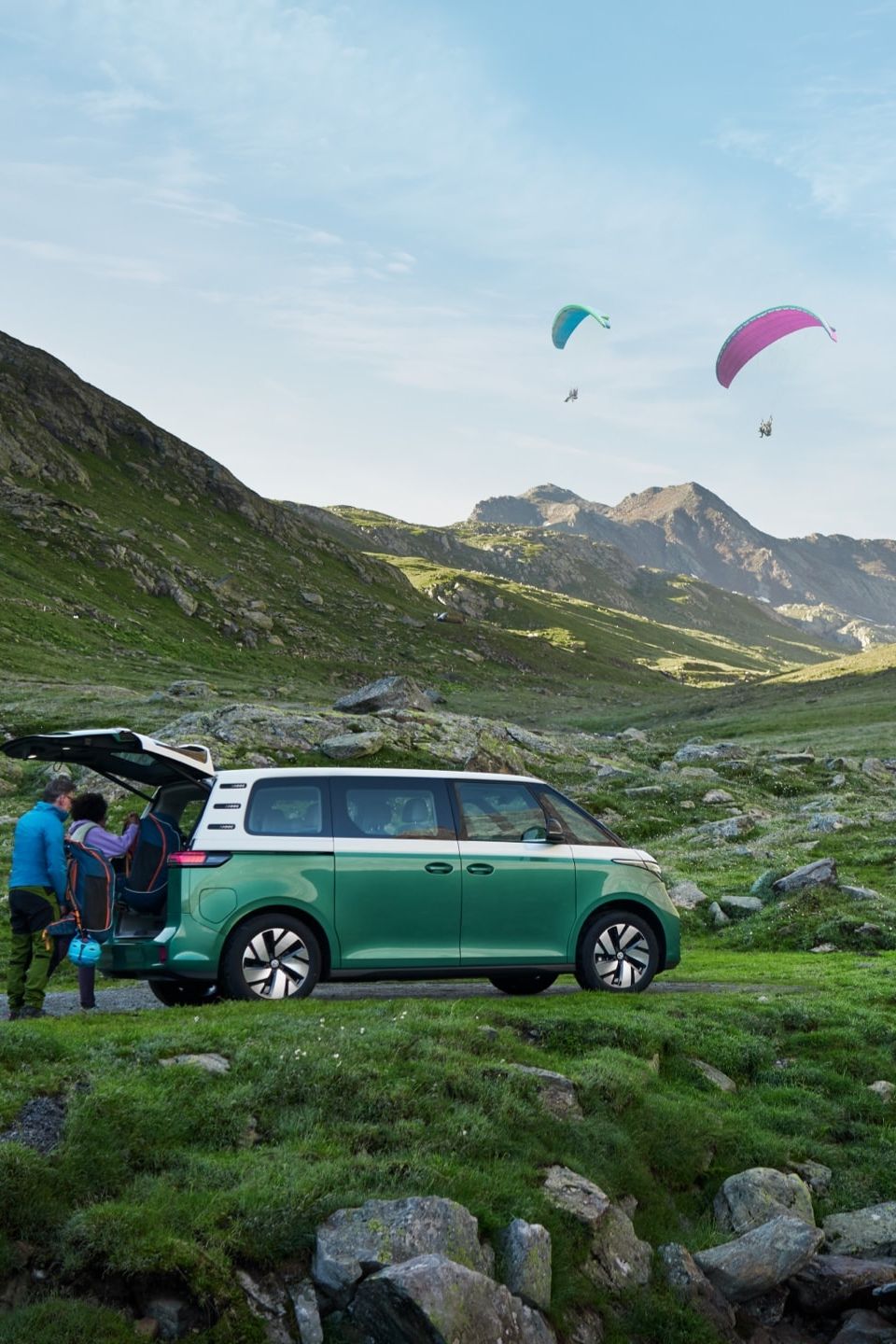 Volkswagen ID. Buzz stojí u horského potoka s otevřenými zadními dveřmi