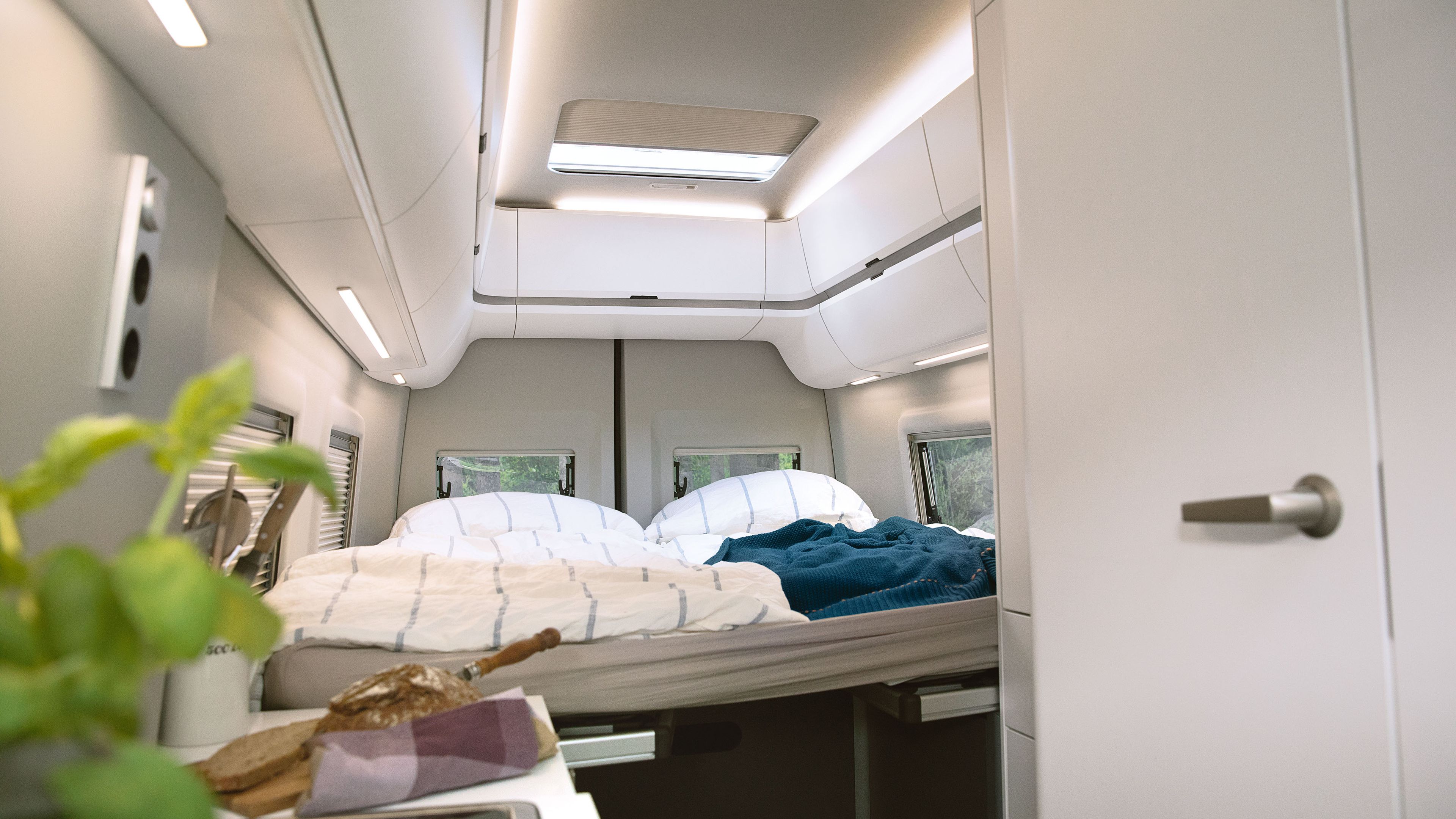 Postel ve voze Grand California 680 s útulným osvětlením interiéru 