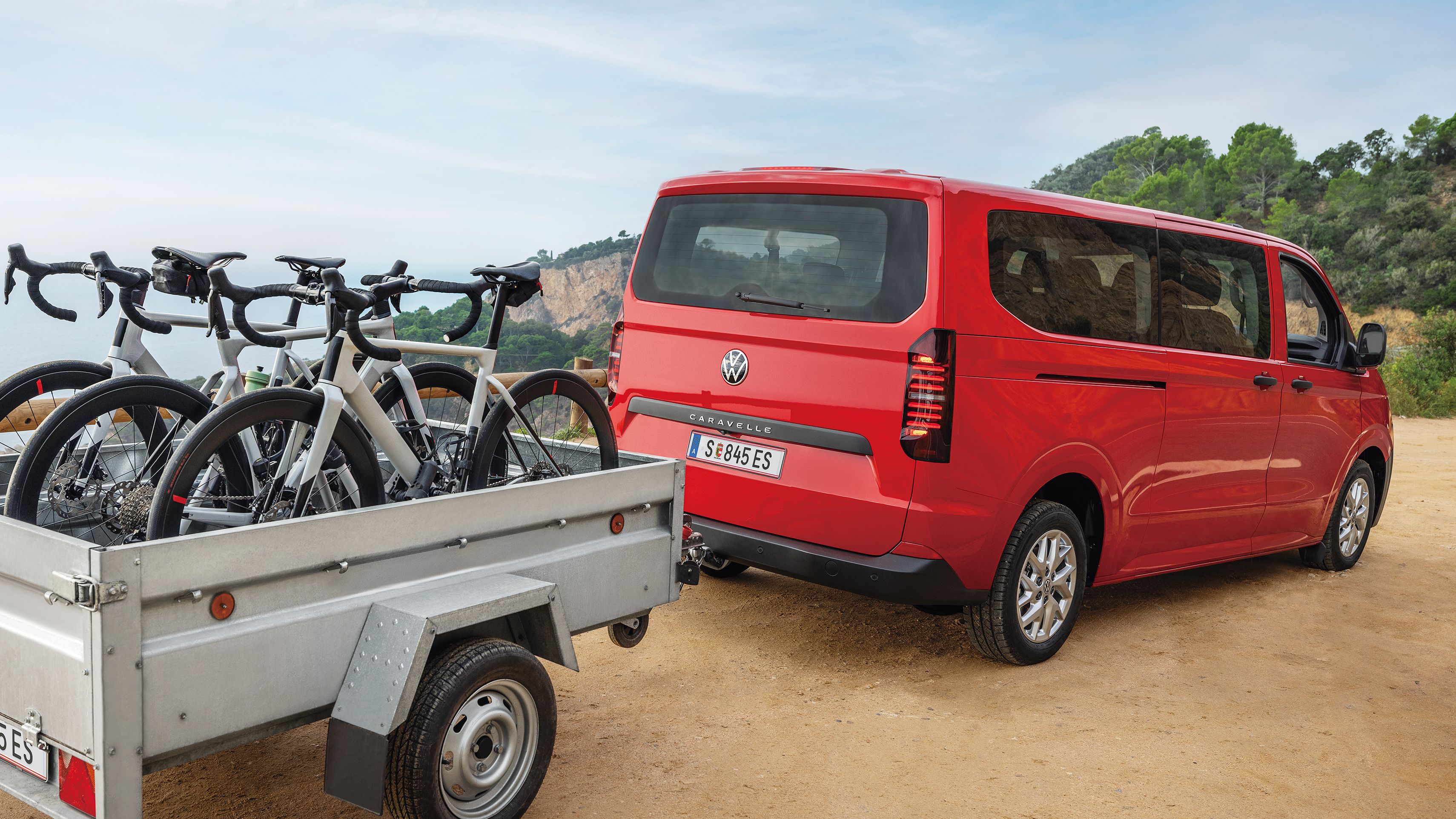 Volkswagen Caravelle v červené barvě s přívěsem