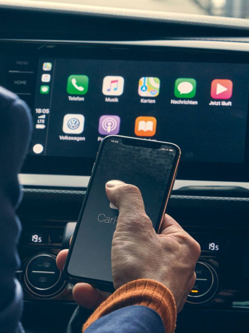 Ein Mann bedient sein Smartphone in einem VW Nutzfahrzeug