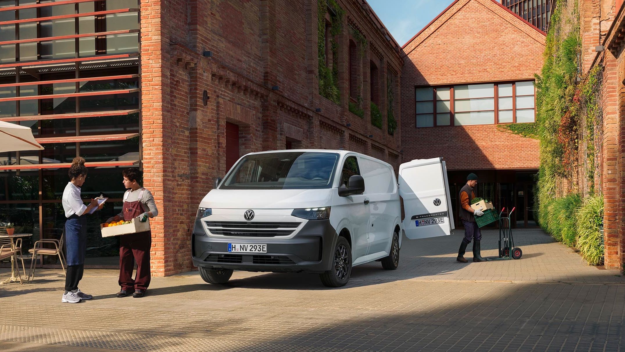 Volkswagen Transporter bílé barvy stojící u budovy